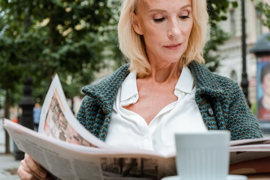 Woman with menopause reading a newspaper and enjoying life