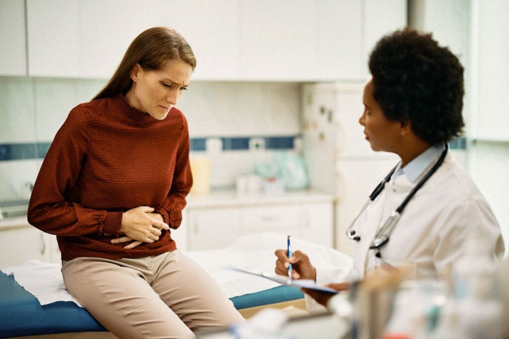 Femme en consultation chez un médecin pour des douleurs abdominales et pelviennes.