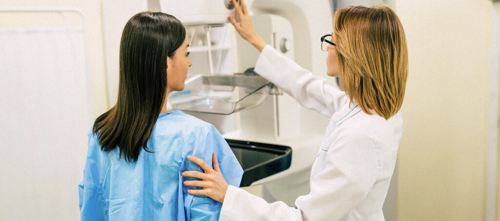 Young woman doing a mammography examination at a private clinic with a professional female doctor.